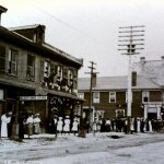 The Albion can be seen at the centre where many people of all ages line the street. There is a large hydro pole that sits at the centre of the photo outside the Albion