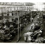 The factory floor at Bertram's. Men are working in various sections of the shop.