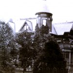 closer look at the steeple tower on the Lawnview house, with trees in the foreground.