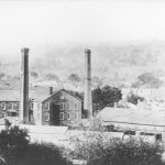 the screw factory with smoke stacks on either side of a building. The escarpment can be seen in the background.