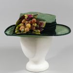 Full view of green straw hat and faux grapes.