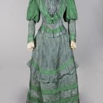 dark two-tone green floor length dress with gigot sleeves.