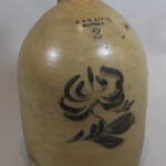 Heavy stone jug with a floral design on the front and the inscription "P & R Laing Dundas 2" near the spout