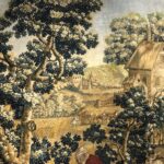Detail of houses, trees, and a horse drawn cart in the background of the tapestry