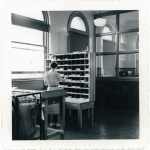 Woman sorting letters into mail slots.