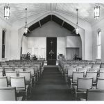 Rows of pew chairs in front of the altar.